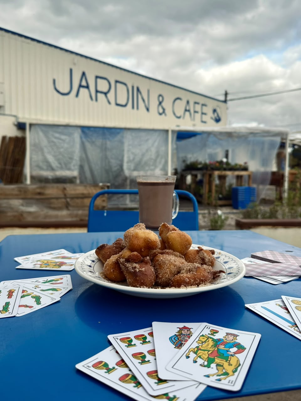 Mesa de desayuno en La Romería Jardín & Café, con plantas de fondo