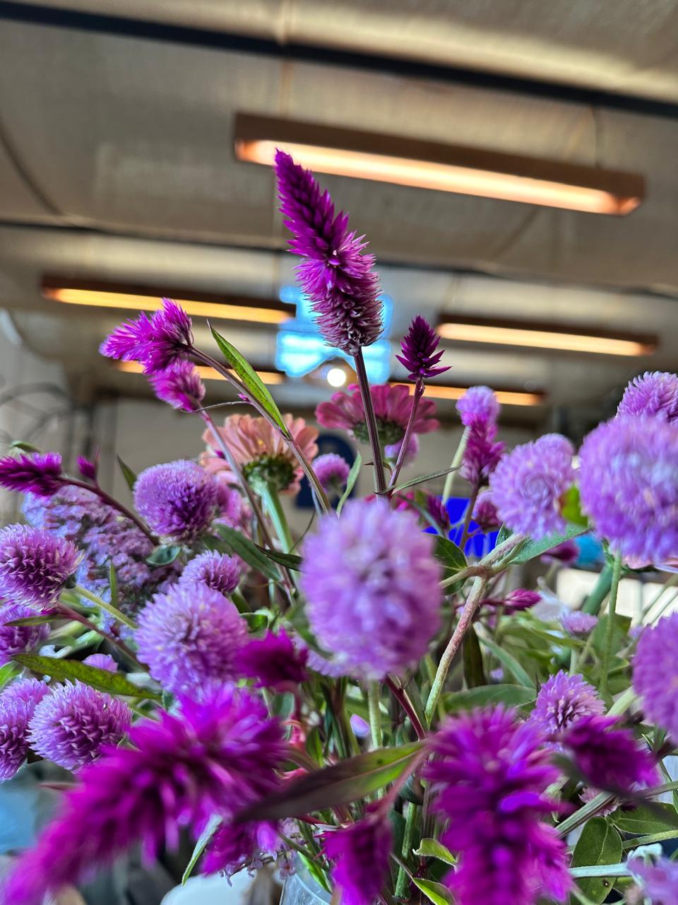Flores moradas en florero sobre la mesa del taller