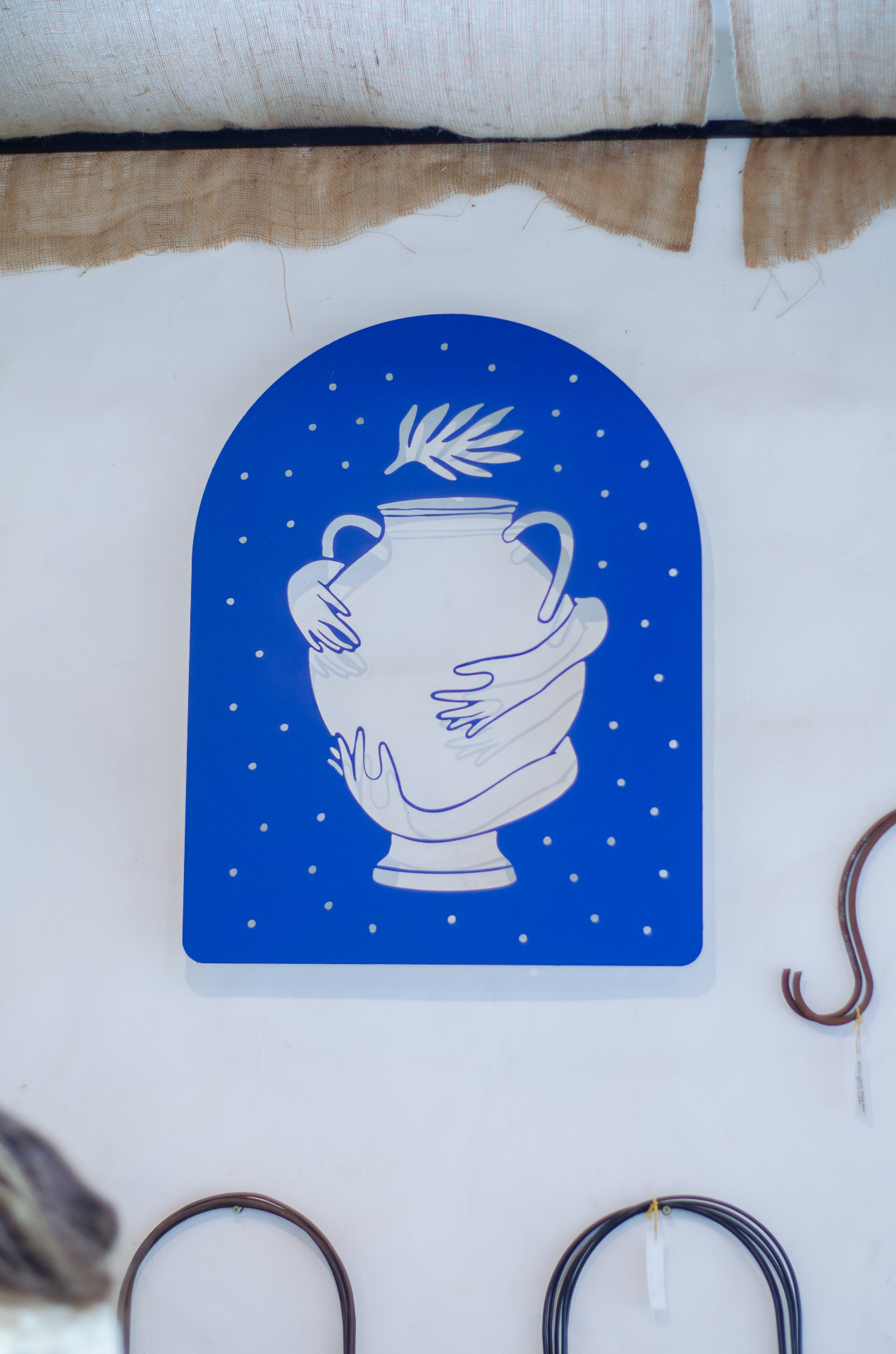 Cartel azul ilustrado de La Romería con una ánfora blanca