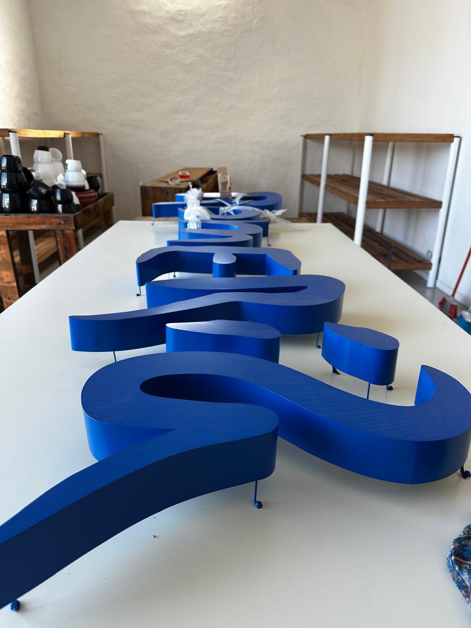 Letras azules de La Romería en proceso de armado